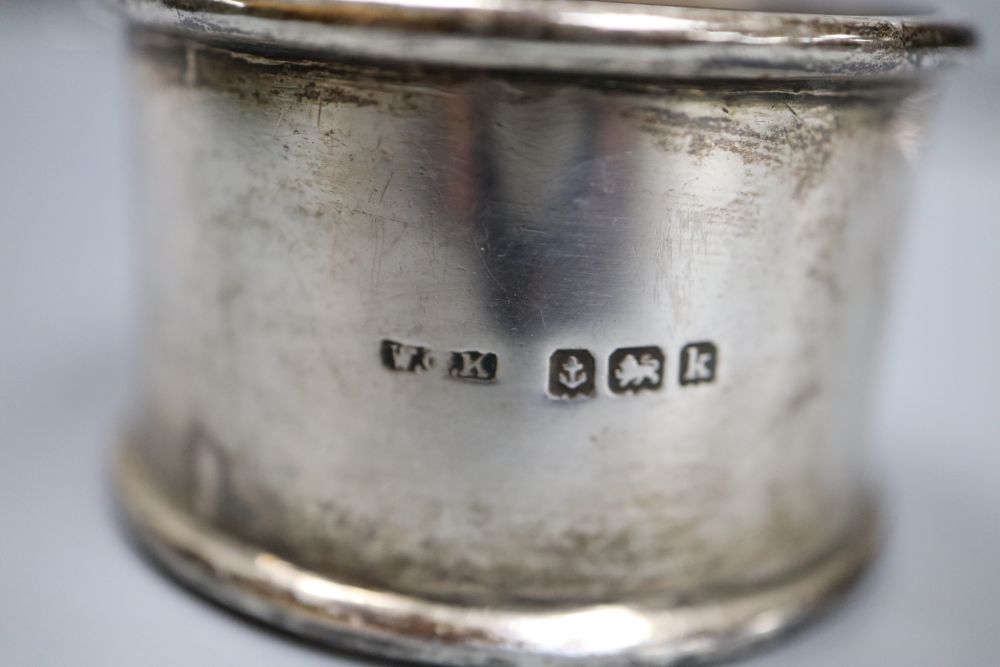 A pair of silver napkin rings, four other silver napkin rings and a small plated trophy cup.